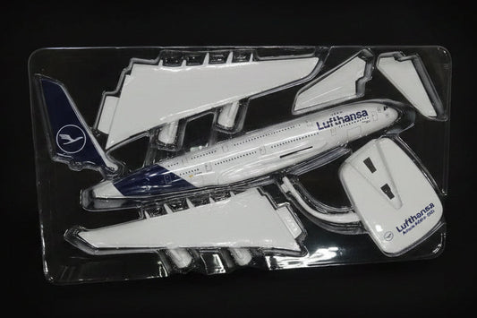 Model airplane parts in a clear plastic package on a desk.