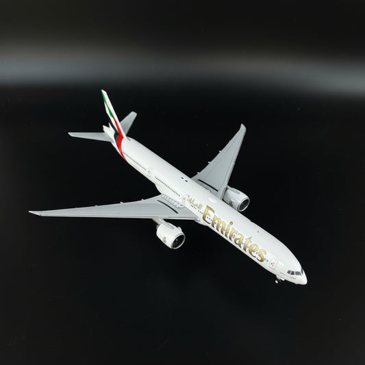 Model airplane on a clear stand with Emirates branding on a wooden surface